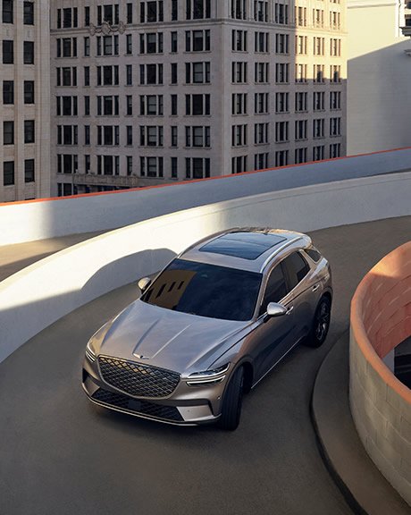 An impressive silver SUV snakes down a curving concrete ramp in the city's business district