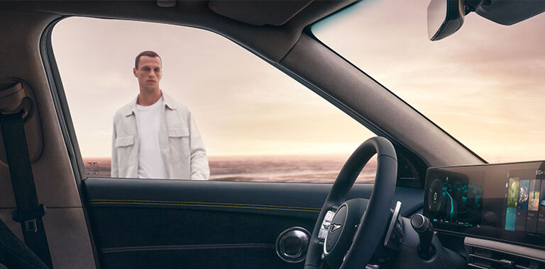 Man approaching GV60 seen through driver-side window