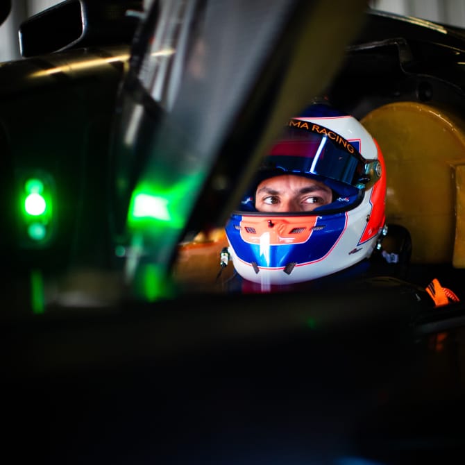 WEC driver wearing a helmet seated in a hypercar, headshot