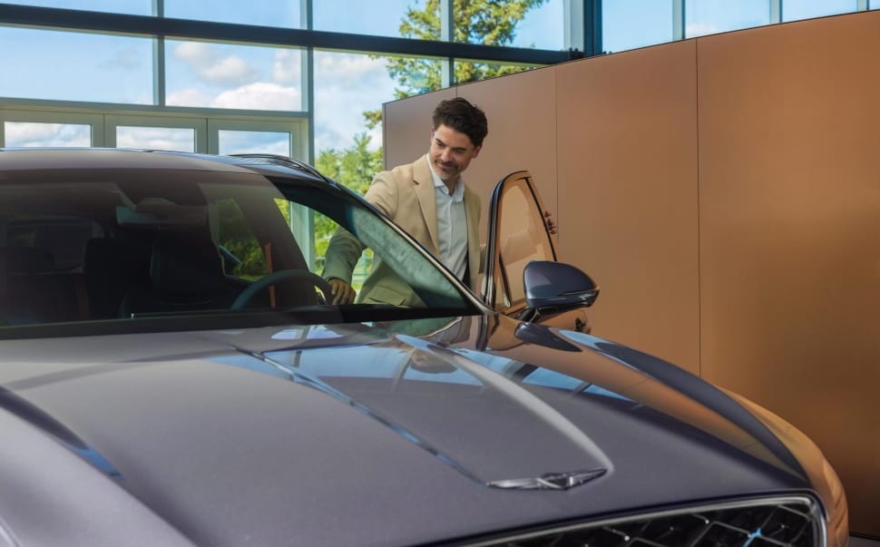 Homme montant à bord d'un Genesis GV70.