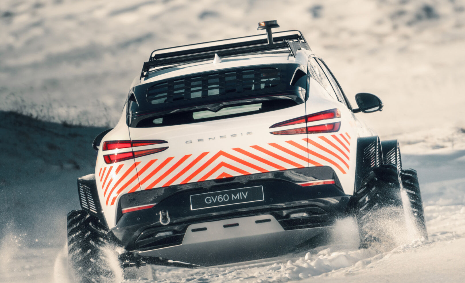 Rear view of the GV60 MIV driving showcasing the rear hatch rack and the loop pattern of the rear roof rack.