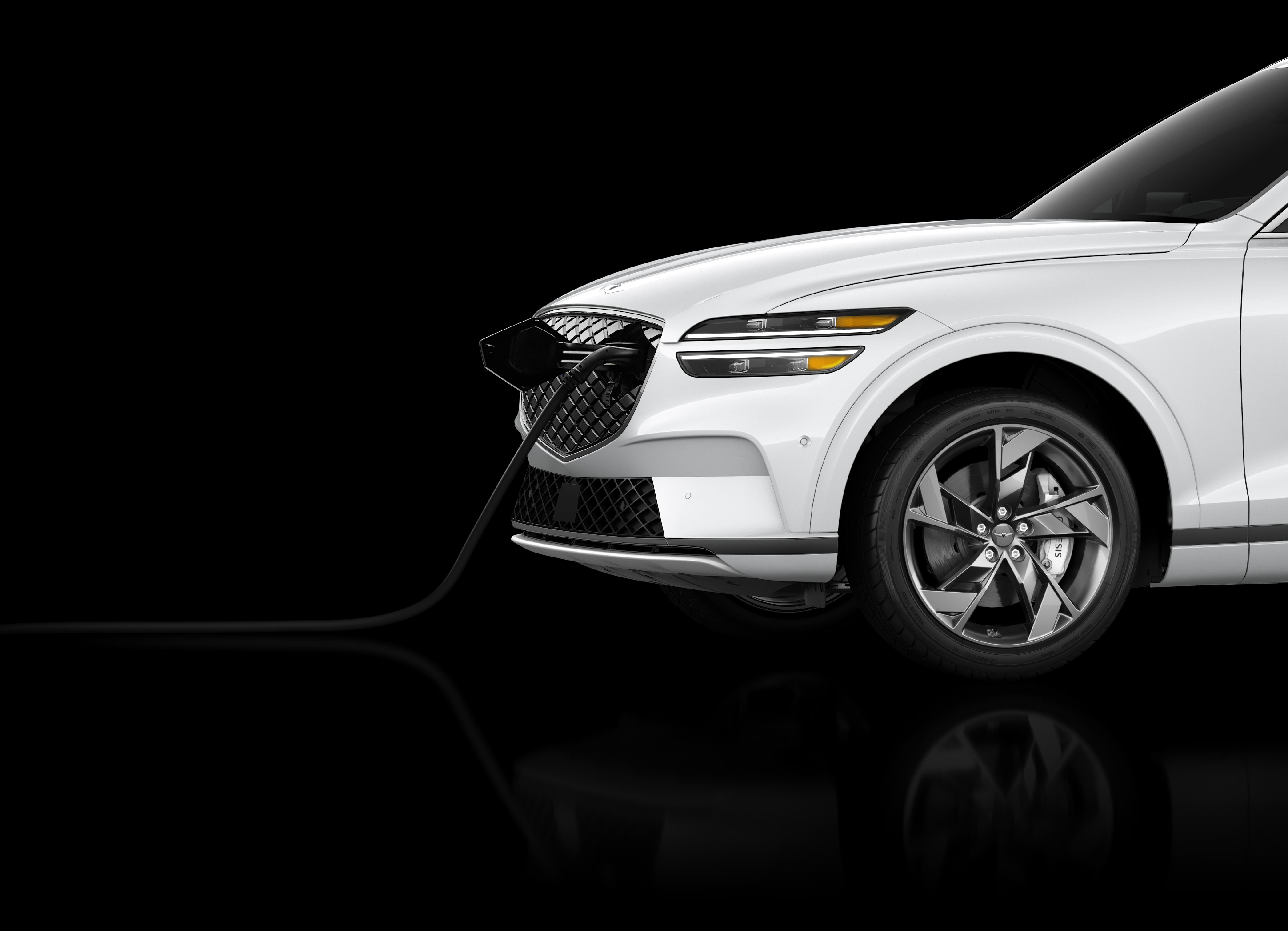 The white Electrified GV70 electronically charges against a black background. 