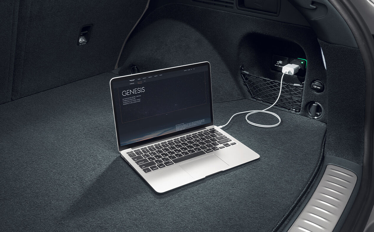A laptop is charging inside the car through interior V2L charging.