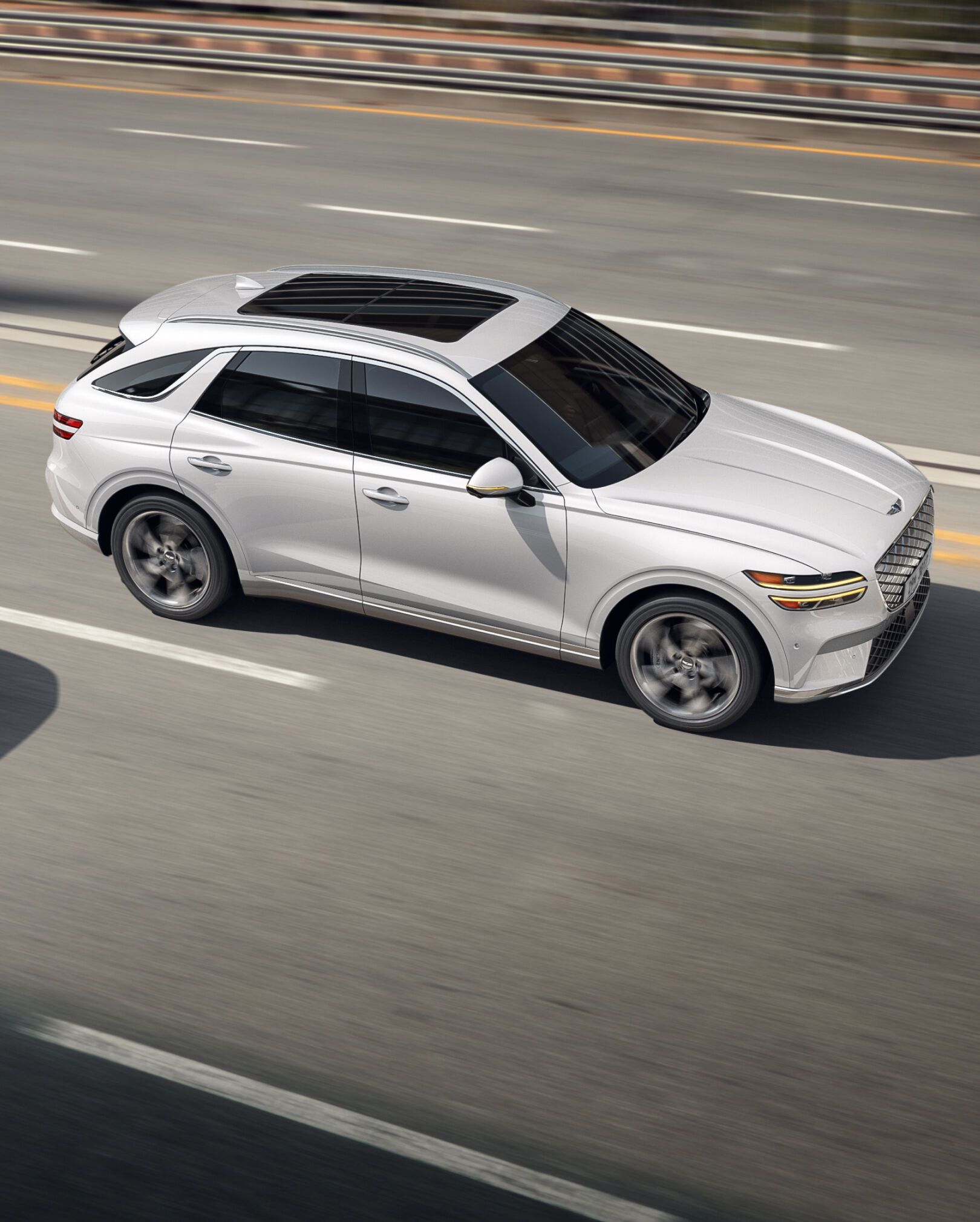 White GV70 driving on the highway