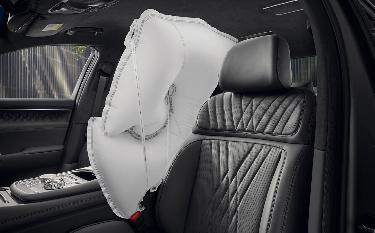 A white airbag is inflated between the driver and passenger seats in Modern Gray interior.