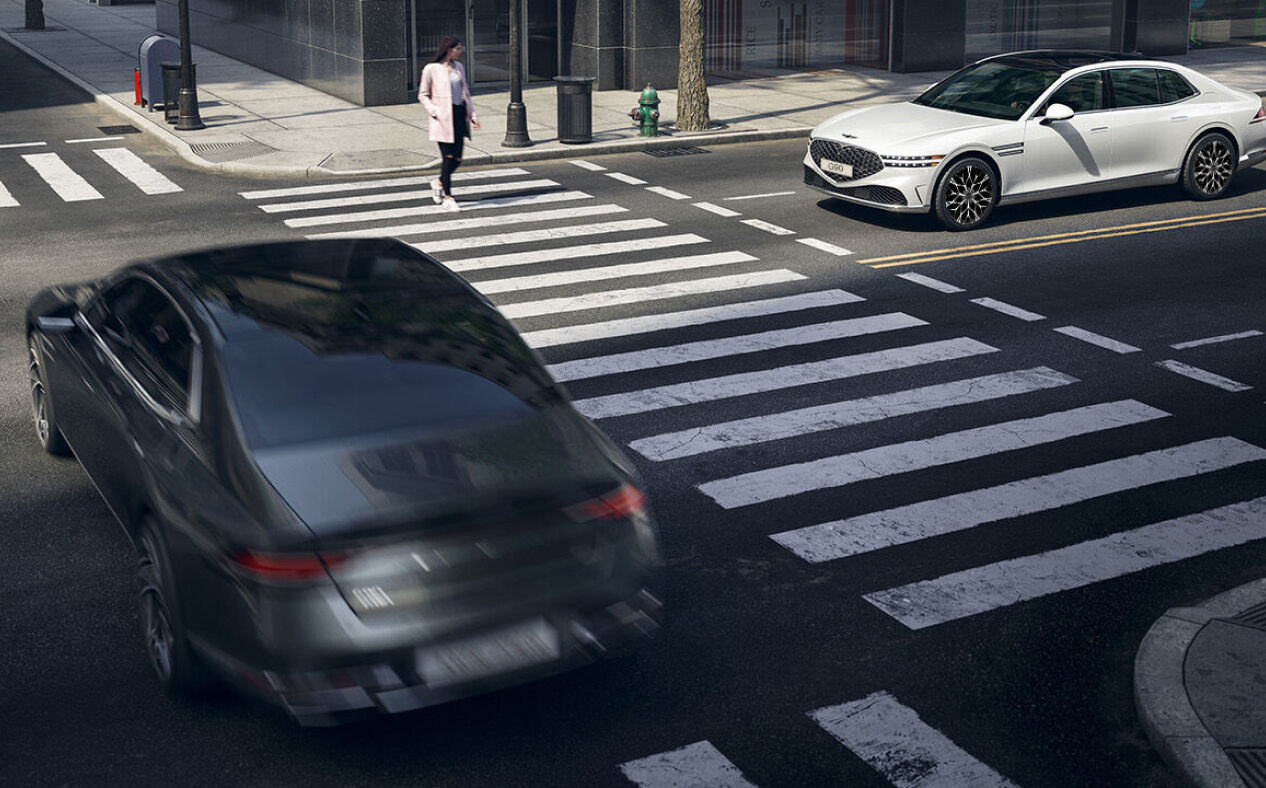 A pedestrian is crossing the crosswalk while Uyuni White G90 is stopped.