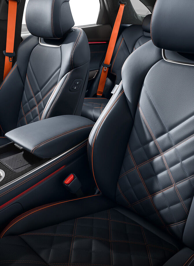Les sièges du GV70 Sport, avec leurs coutures orange et leur design en cuir noir, sont accentués.