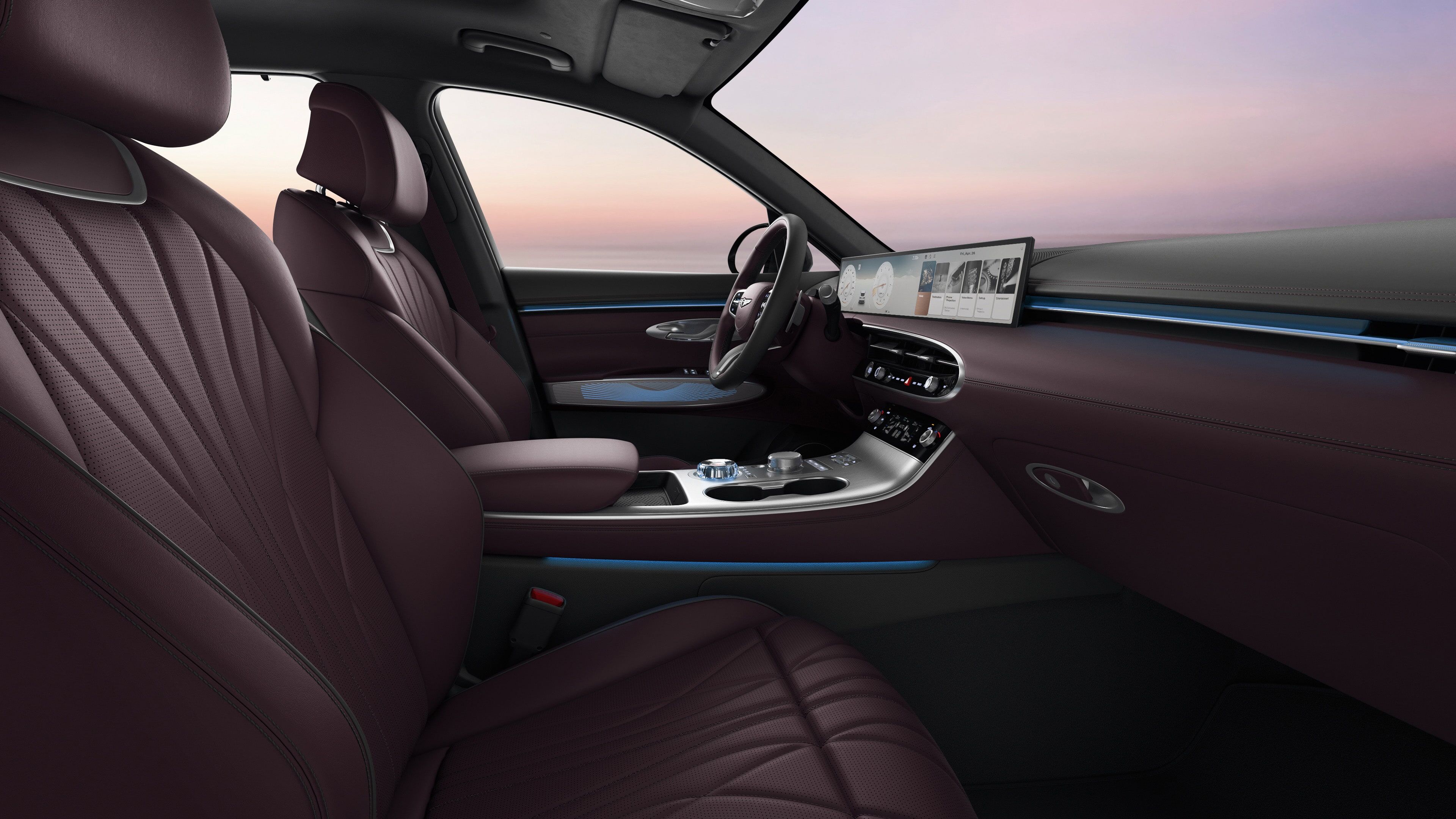 You can see the driver's seat of the GV70 with a two-tone colour combination of Slate Grey and Velvet Burgundy. The view is from the passenger seat, and there's a subtle blue mood lighting.