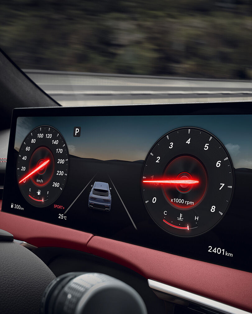 The instrument cluster inside the wide display screen are enlarged. The gauge needles are highlighted in red.