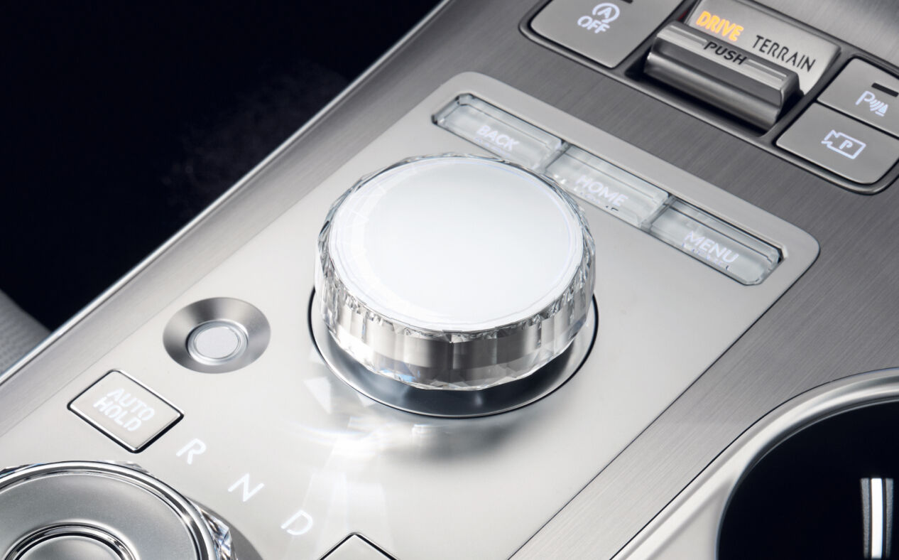 The integrated controller located between the driver's seat and the passenger seat is highlighted. Various buttons for control are present alongside the controller.
