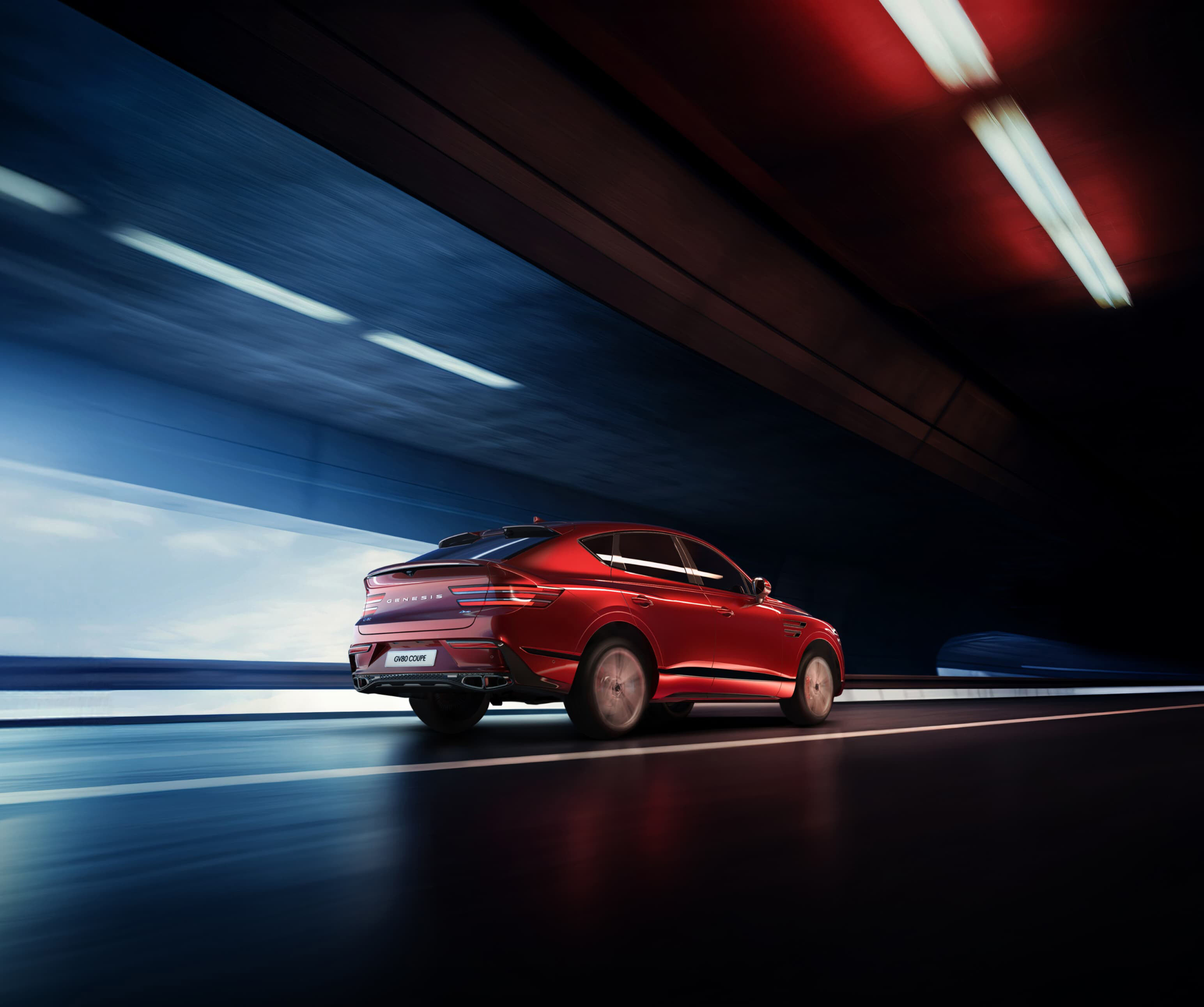 Le GV80 Coupé en Rouge Mauna roulant à vive allure dans un tunnel.
