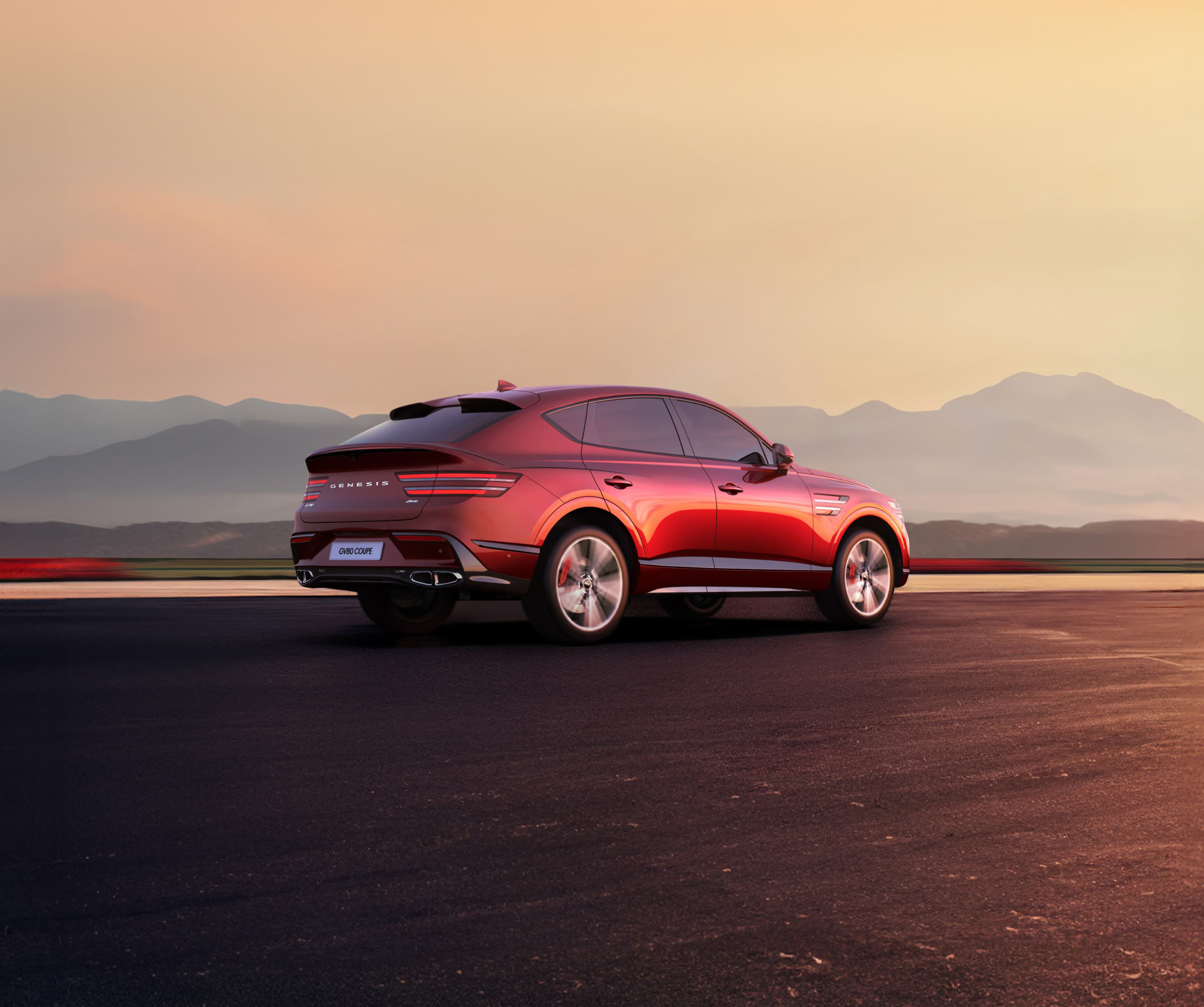 Zoom sur le texte pour révéler un GV80 Coupé en Rouge Mauna roulant à vive allure.