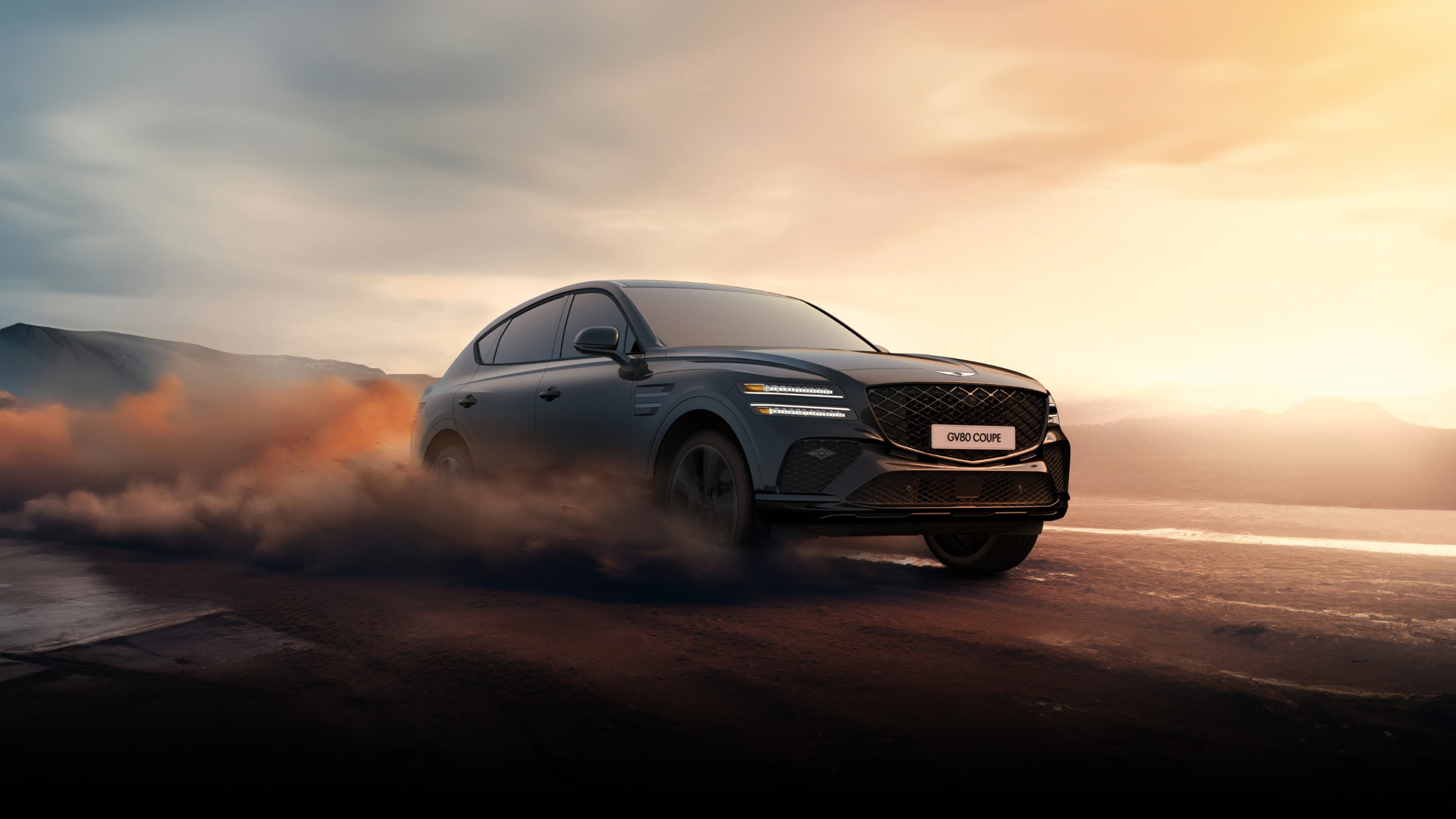 Un GV80 Coupé en Noir Vik roulant sur une plage sablonneuse.