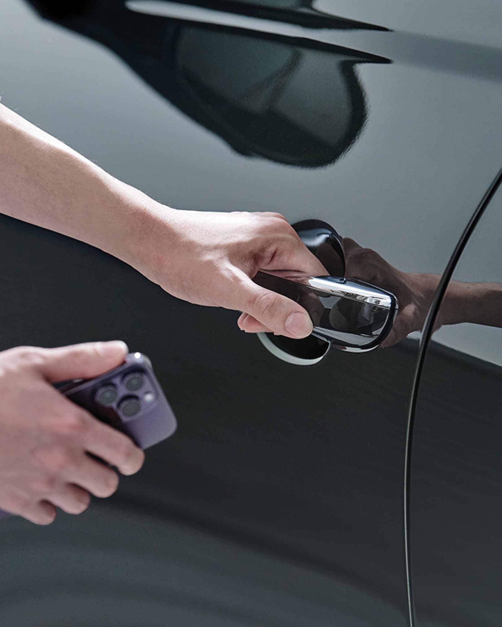 Le conducteur tient un téléphone intelligent près de la portière du véhicule.