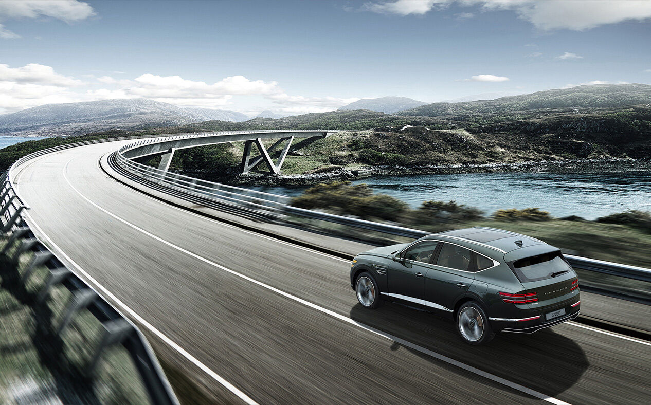 Storr Green GV80 driving fast on the highway while maintaining a safe distance from the vehicle in front.
