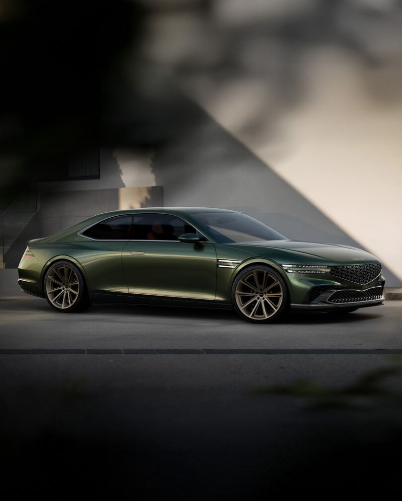 Against a shadowy wall, the Genesis X Gran Coupe Concept is parked on its left side.