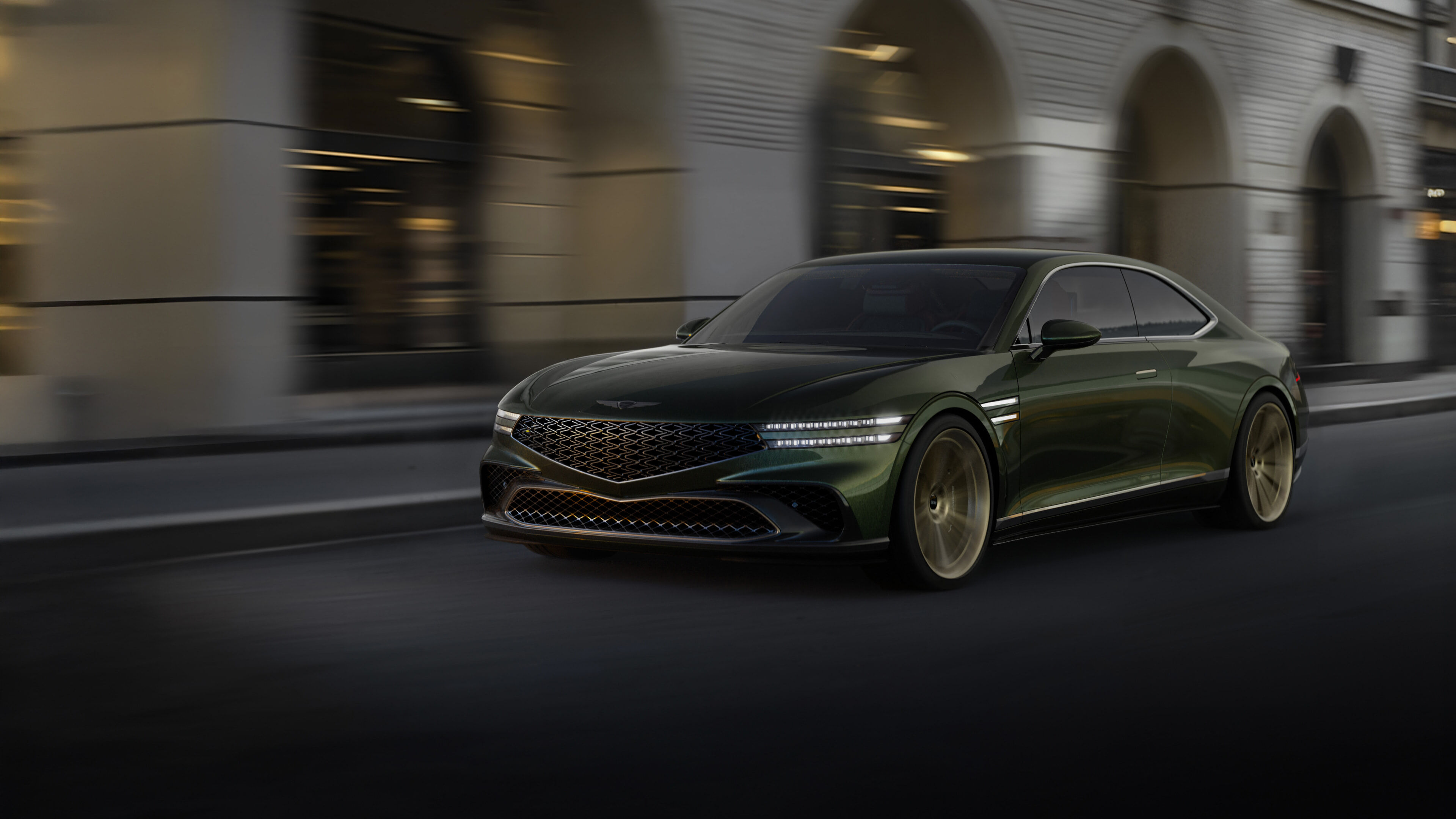 A Genesis X Gran Coupe is driving with a modern city in the background.