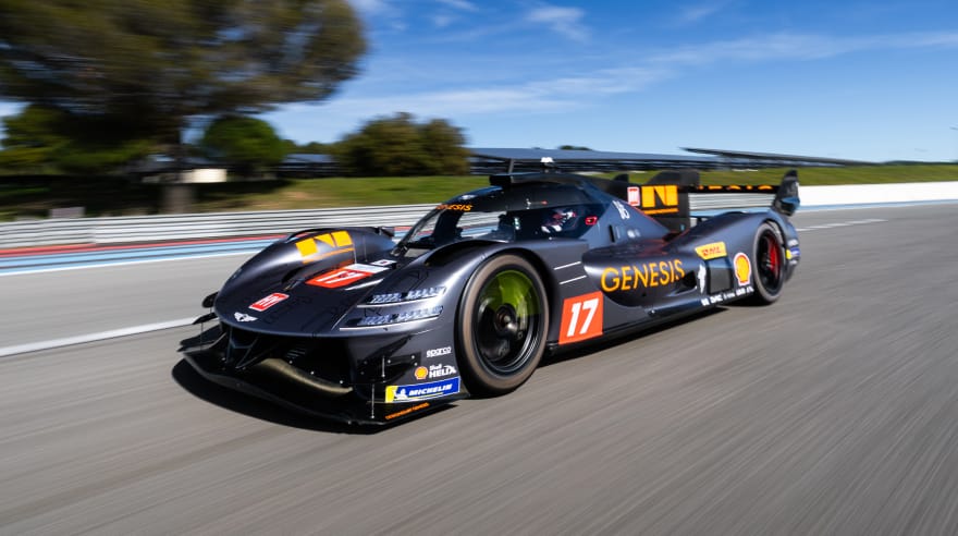 Front three-quarter view of the GMR-001 hypercar racing on a circuit