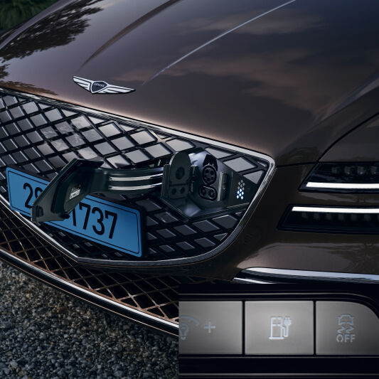 A charging door located in Electrified G80's front crest grille is open. The separately inset image at the bottom shows several function buttons related to charging.