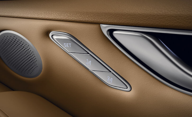 Three buttons located on the front seat door are shown. The upper button is labeled SET, followed by the middle and lower buttons with images to adjust the shape of the seat.