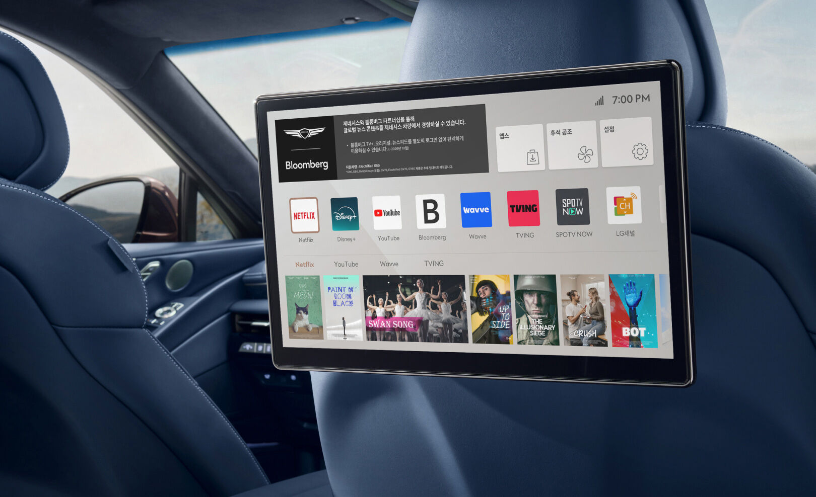 View the rear smart entertainment system display placed behind the headrests of the front seats. A variety of content is shown on the screen.