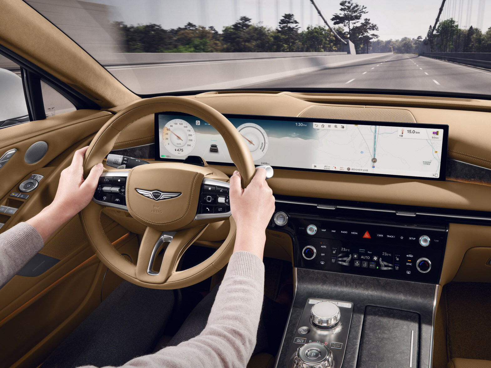 While driving the vehicle, a partial view of the driver in the driver's seat operating the steering wheel is visible.