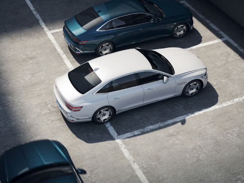 Another vehicle is approaching the rear of an Electrified G80 that is backing out of a parking lot.