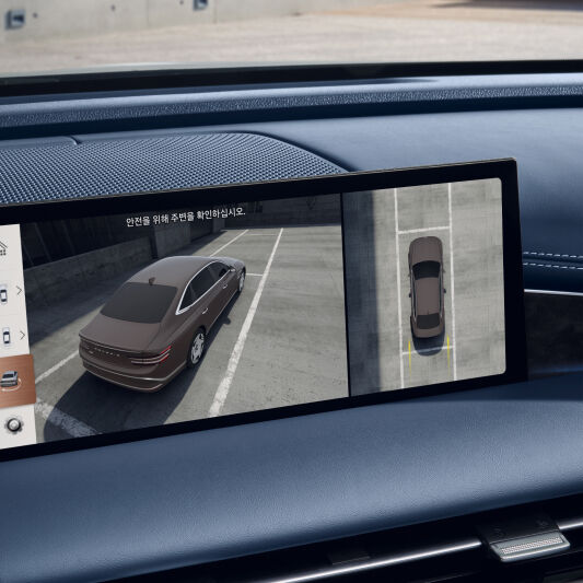 The display screen located in front of the driver's seat shows a split two-part graphic. The left graphic shows a view of the vehicle from the top of the near side, and the right graphic is from the far vertical sky.