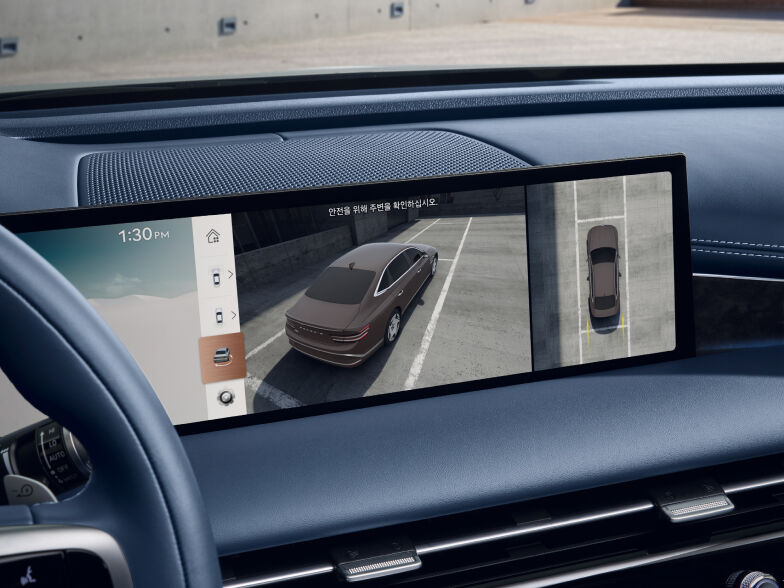 The display screen located in front of the driver's seat shows a split two-part graphic. The left graphic shows a view of the vehicle from the top of the near side, and the right graphic is from the far vertical sky.