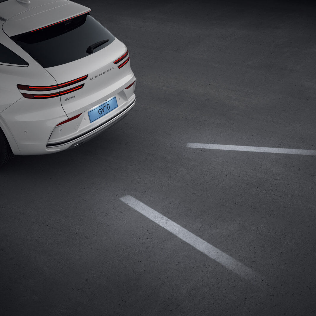 As the vehicle backs up, white guiding lights illuminate the road behind it.