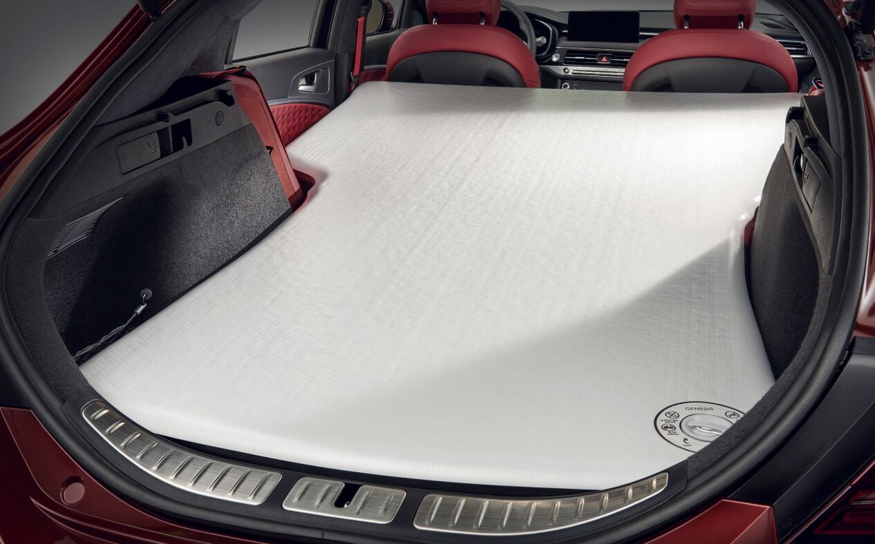 The trunk is open, the second row is folded inside, and an air mat is installed.