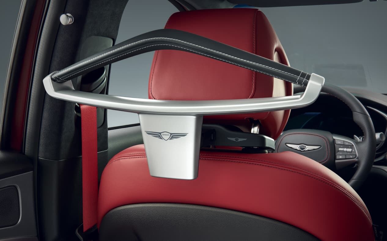 The leather coat hanger is attached to the back of the driver's seat.