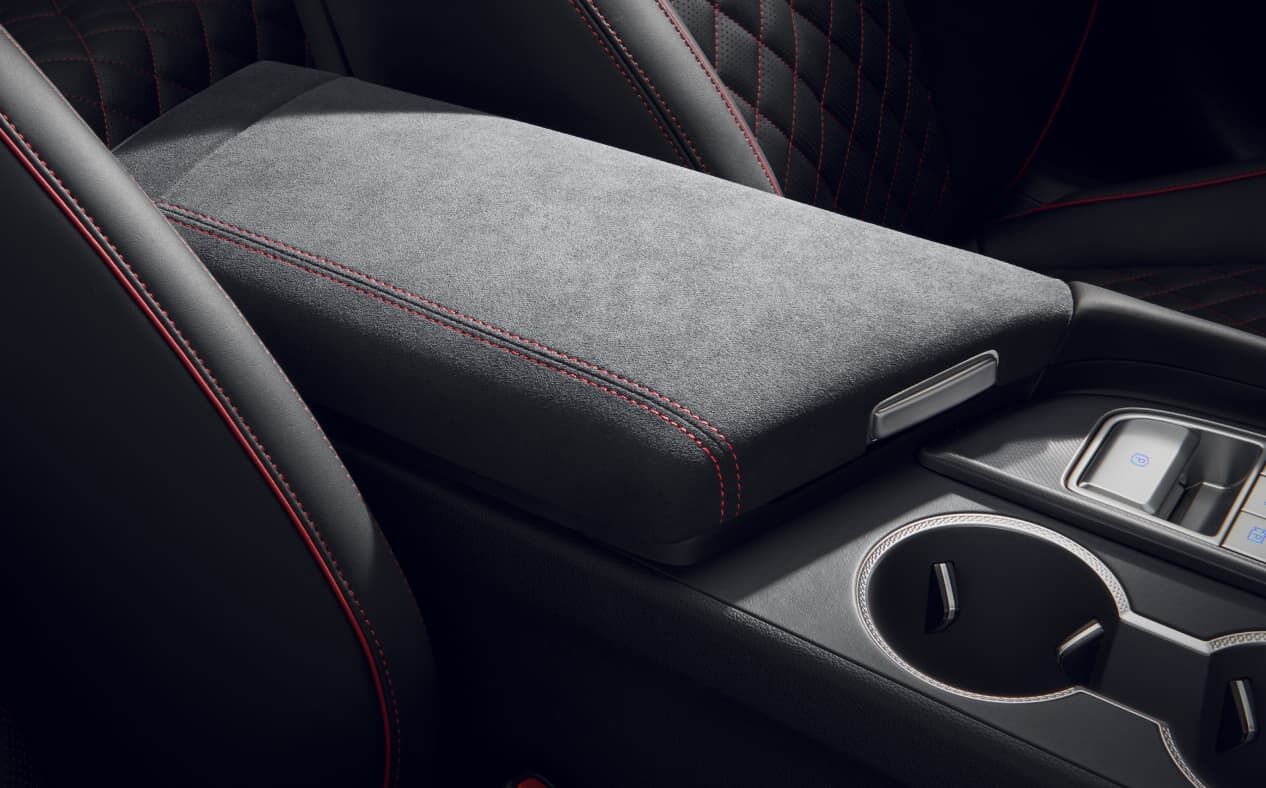 A close-up of the Alcantara console armrest.