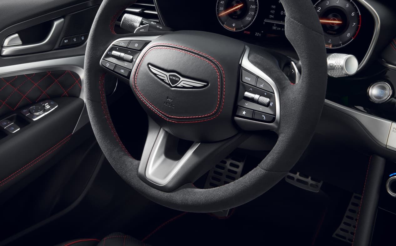 A close-up of the Alcantara Steering Wheel inside the Sports Design Selection Obsidian Black Mono-tone interior.