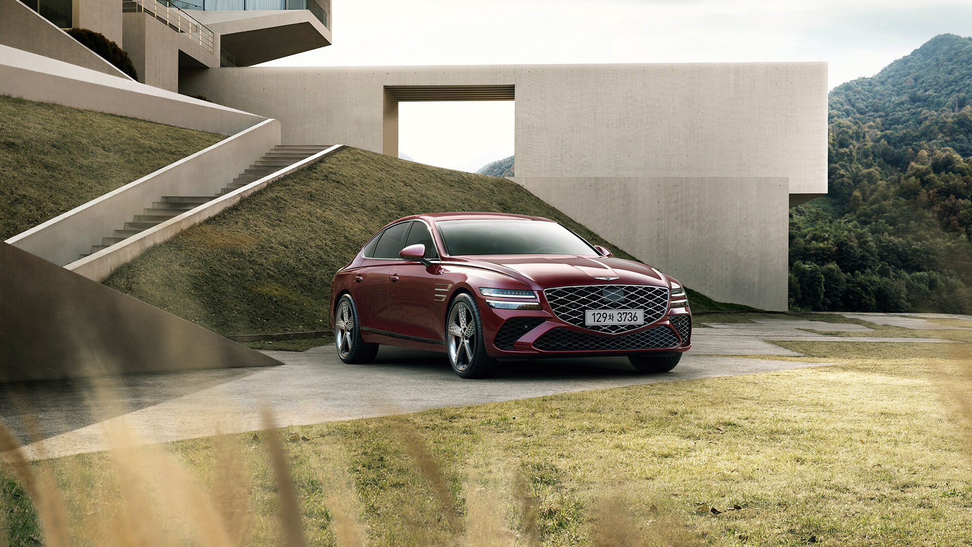 캐번디시 레드 색상의 GENESIS G80 스포츠 모델 차량이 우측면으로 정차해 있습니다.