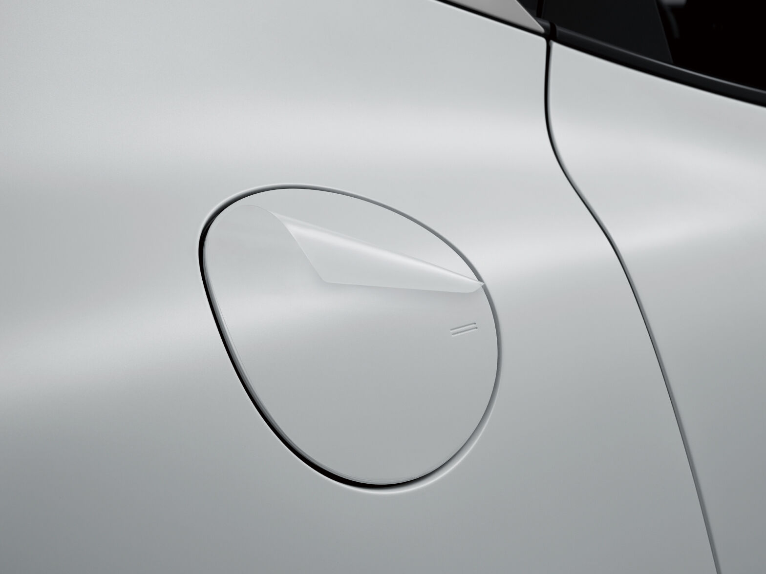 A part of the side of the Uyuni white GV60 vehicle charging port is visible. The film on the vehicle's surface is highlighted.