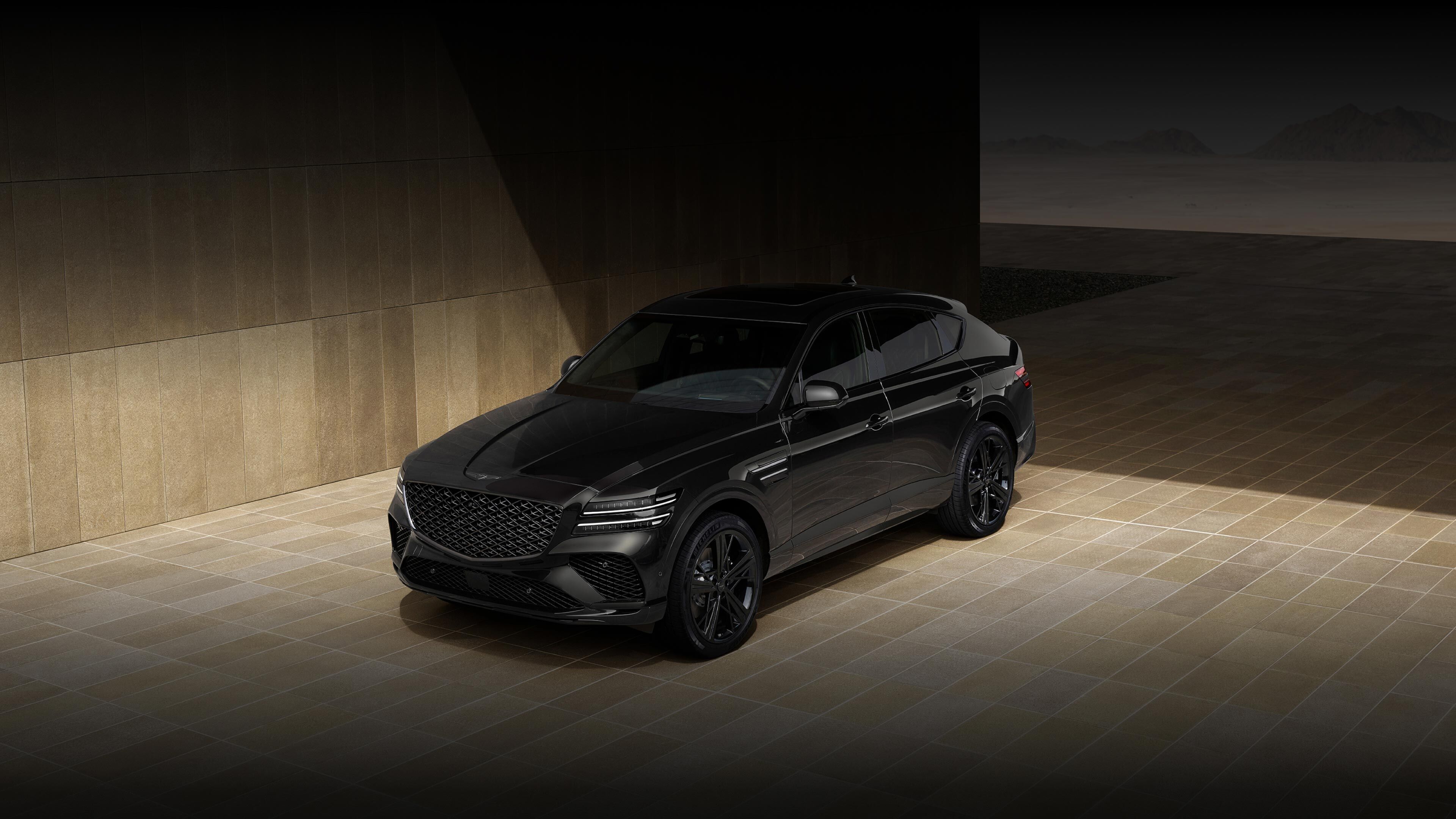 The GV80 Coupe Black is seen from an upper front angle, standing against a backdrop of brown tiles. 