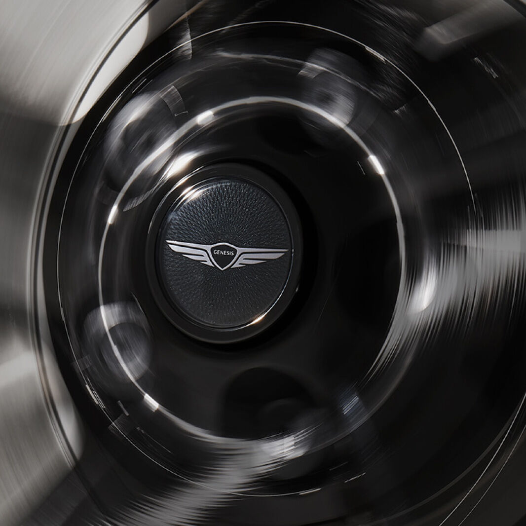 The spinning wheel cap displays a black floating Genesis emblem.