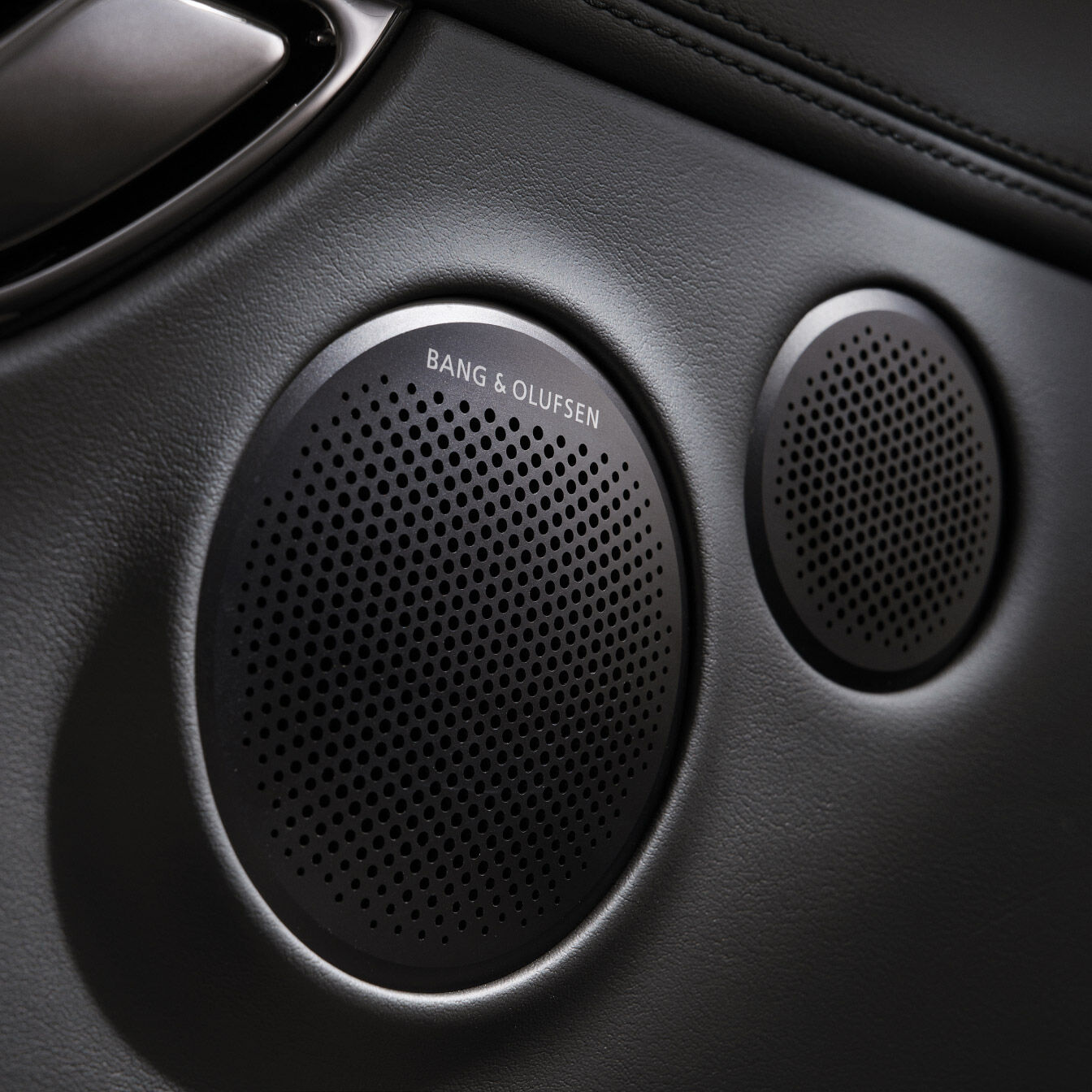 A round speaker with the 'BANG & OLUFSEN' logo is shown. A smaller circular speaker is positioned next to it.