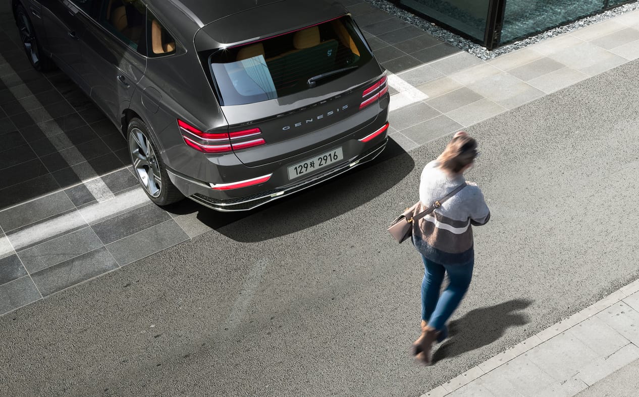 ๋ง์นผ๋ฃจ ๊ทธ๋ ์ด ์์์ GV80์ด ์ฃผ์ฐจ์ฅ์์ ํ์ง์ ํ๊ณ ์์ผ๋ฉฐ ์ฐจ๋ ๋ค๋ก ์ฌ์๊ฐ ์ง๋๊ฐ๊ณ ์์ต๋๋ค.