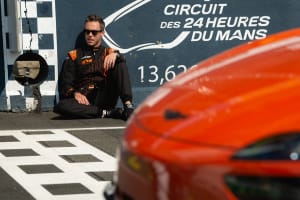 정차되어 있는 주황색 GV60 Magma 앞부분 모습과 레이서가 앉아있는 모습입니다.