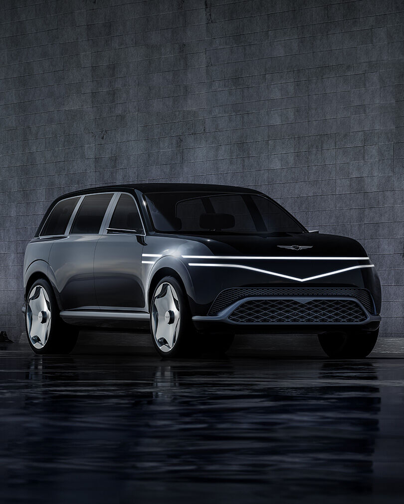 The right front of the parked Genesis Neolun Concept with its lights on is shown.