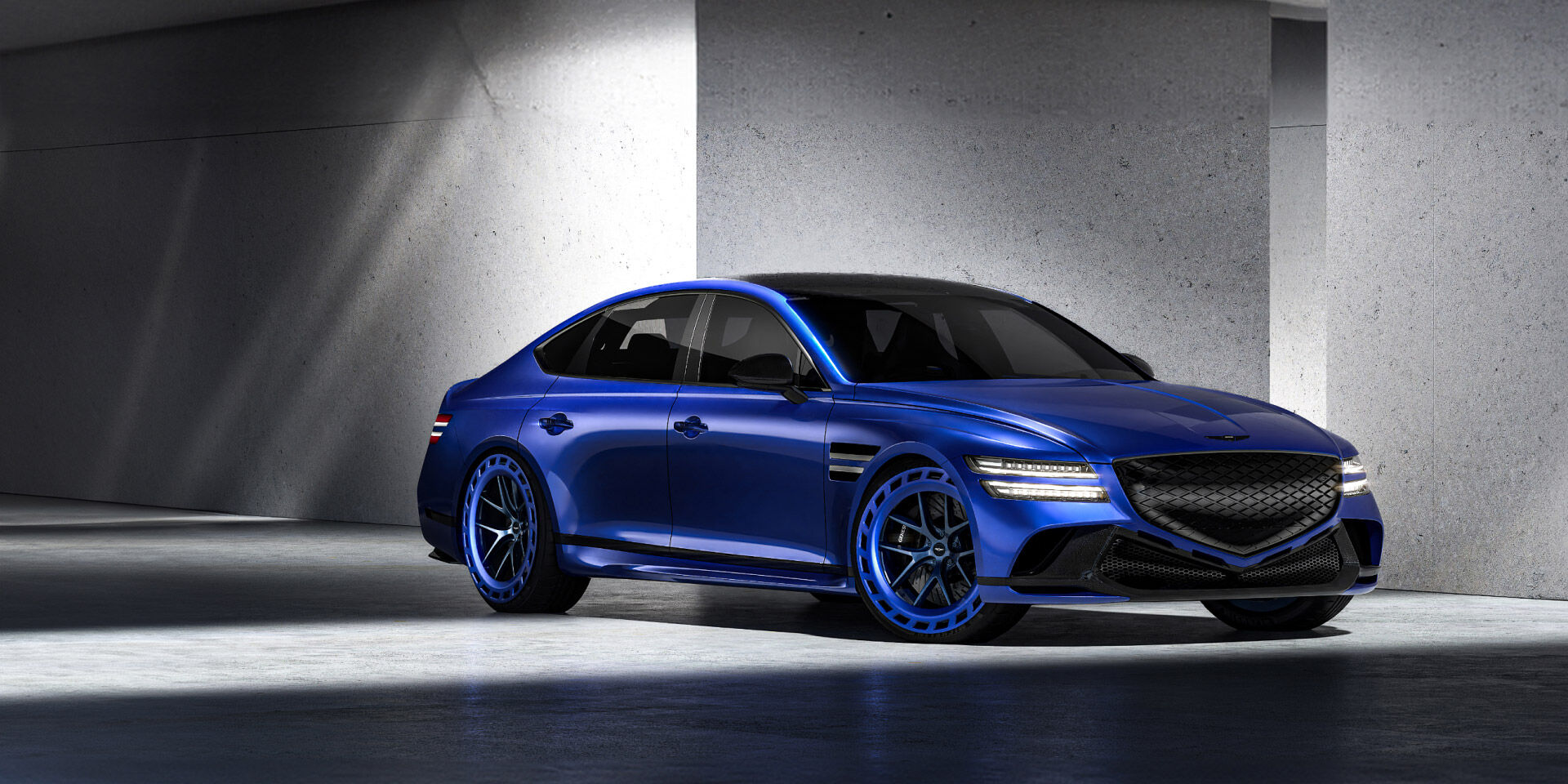 Vision blue two-tone Genesis Electrified G80 Magma Concept is parked in front of a blue-ish gray background. The floor is concrete.