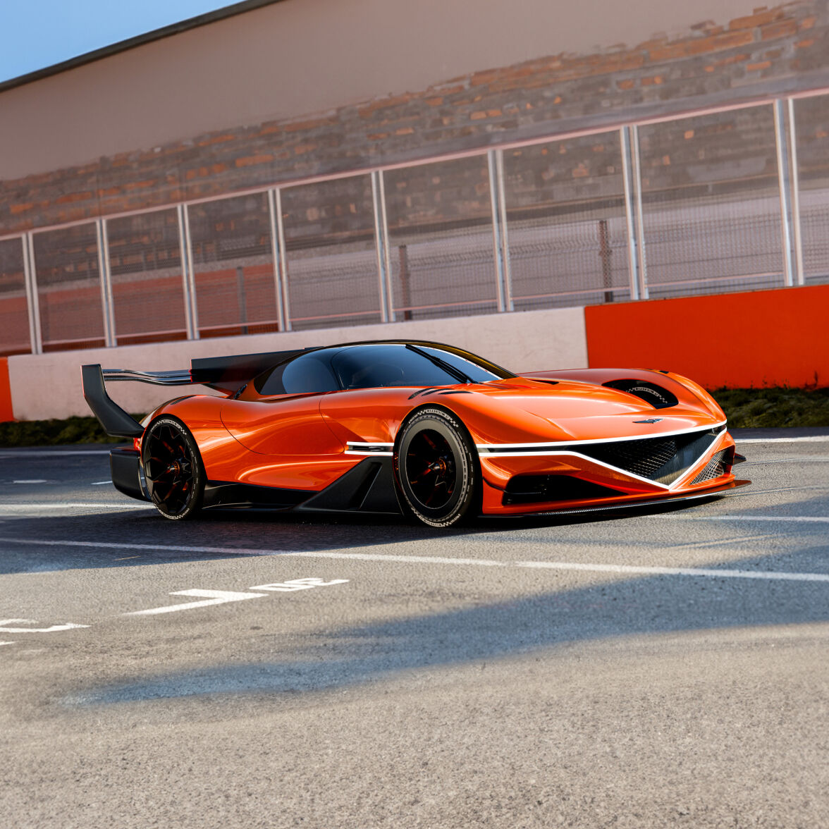 A magma orange colored Genesis X Gran Racer Concept is parked on a race track.