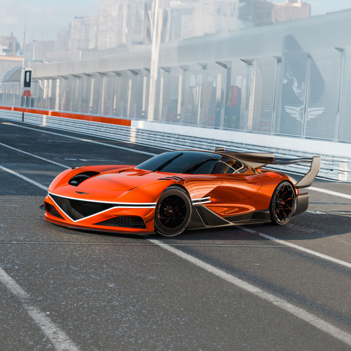 A magma orange colored Genesis X Gran Racer Concept is parked on a race track, receiving sunlight on its front fascia.