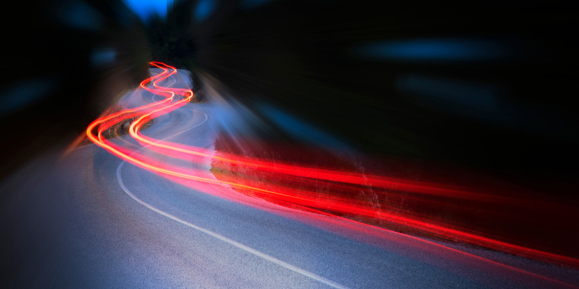 The background features a dark blue sky and a road that conveys a sense of speed.