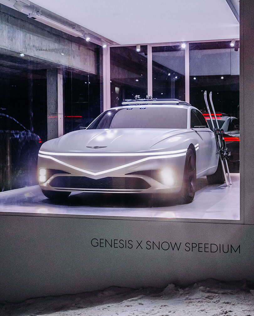 The white-colored X Snow Speedium concept vehicle with the lights turned on.
