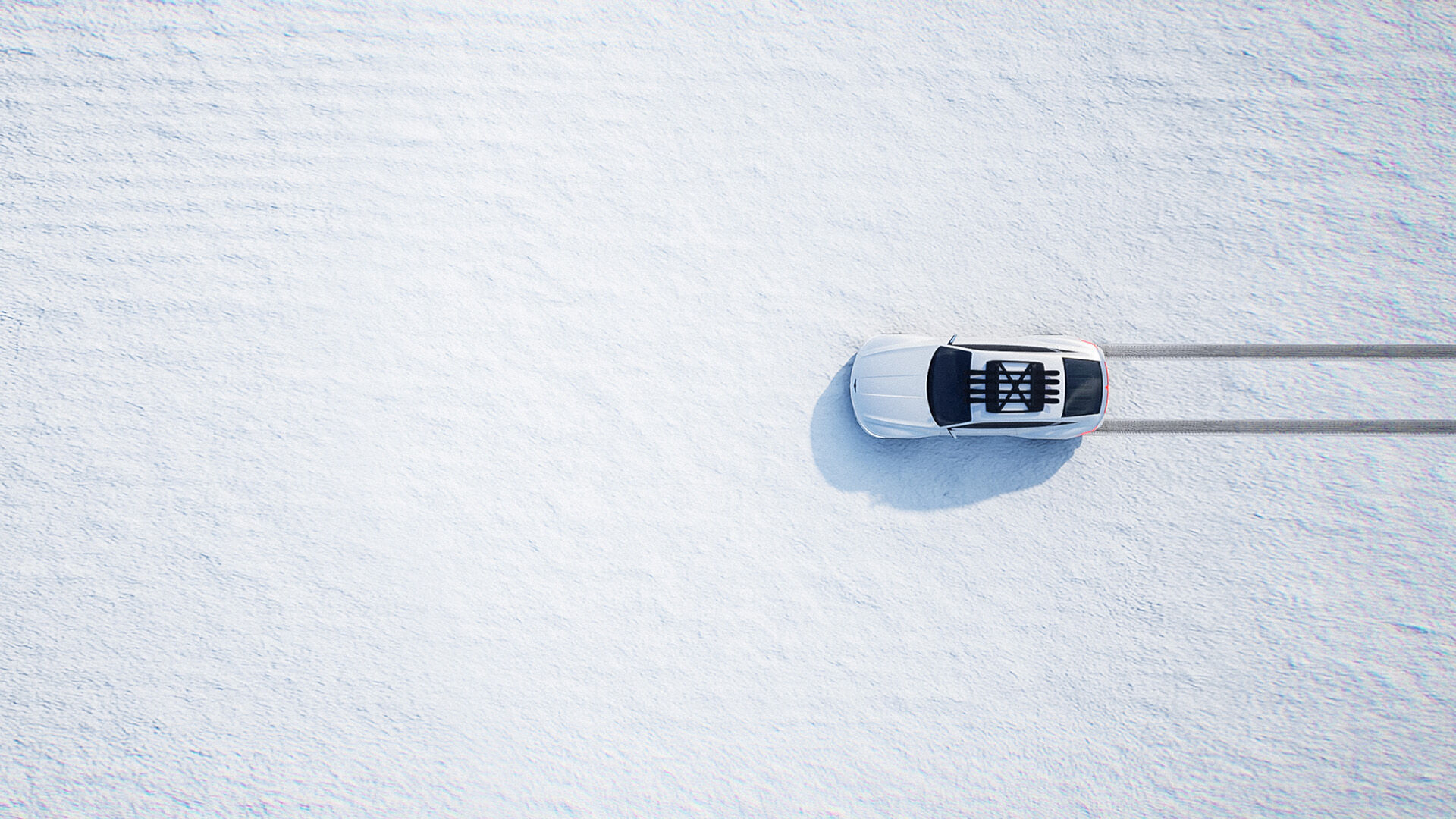 The white Genesis X Snow Speedium concept car drives across freshly fallen snow, making wheel marks across horizontally.
