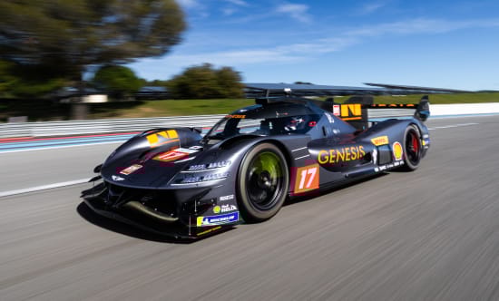 Front three-quarter view of the GMR-001 hypercar racing on a circuit