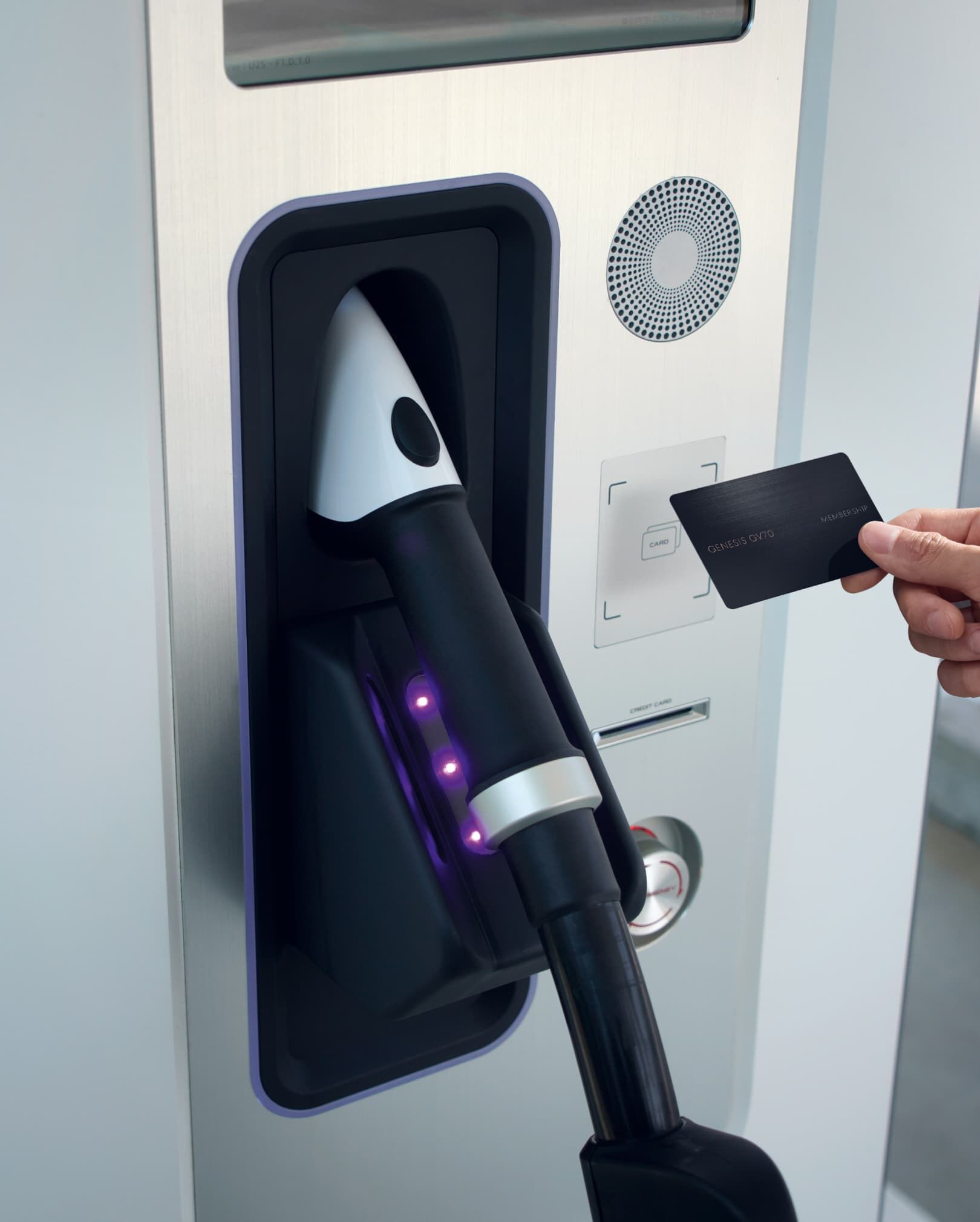 A person holding a top-up card taps the charging terminal reader.